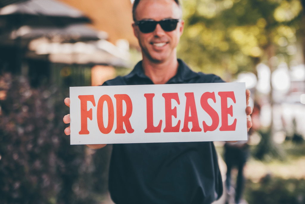 man holding for lease sign