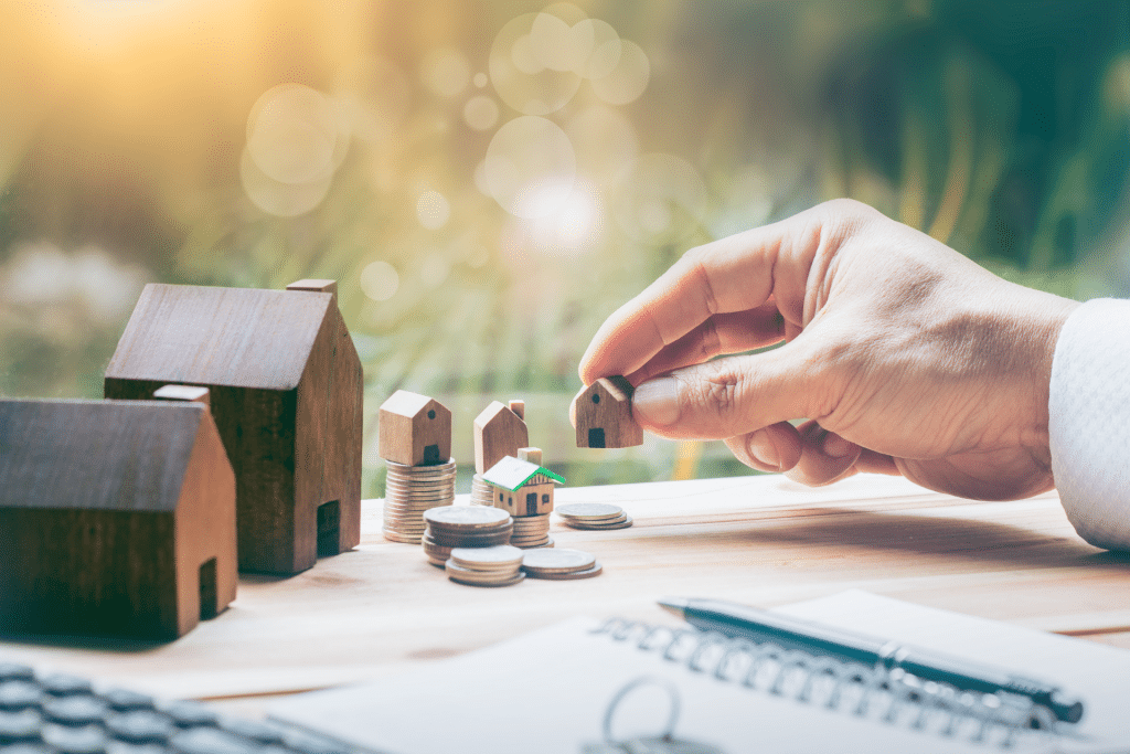 hand near money and small houses