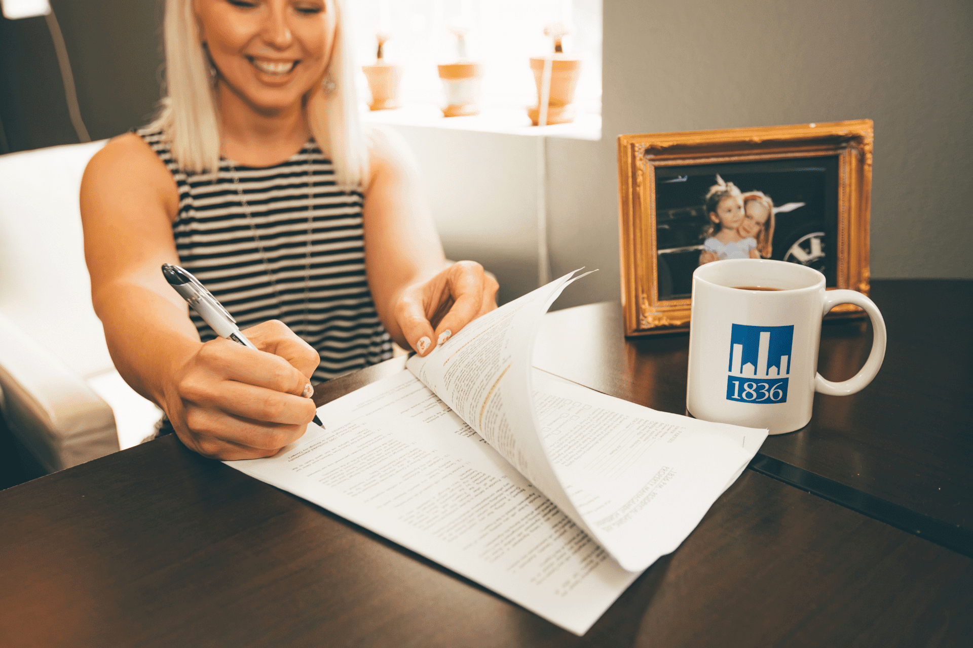 woman signing a lease document