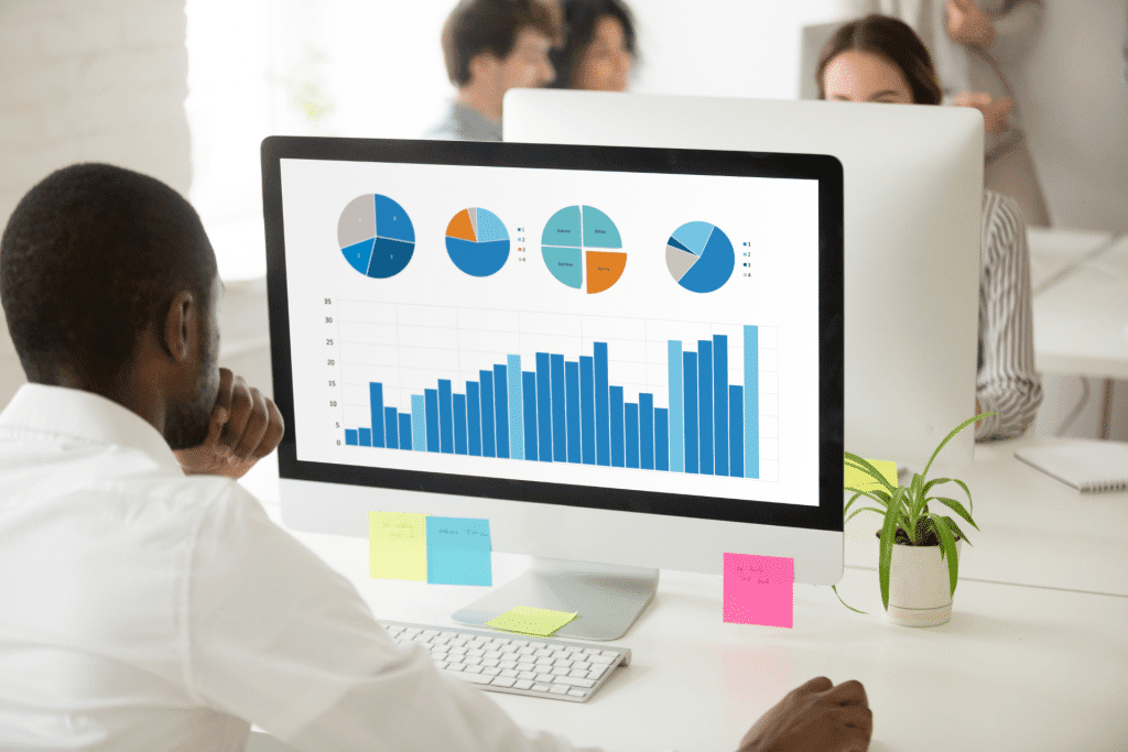 man looking at computer screen with data charts