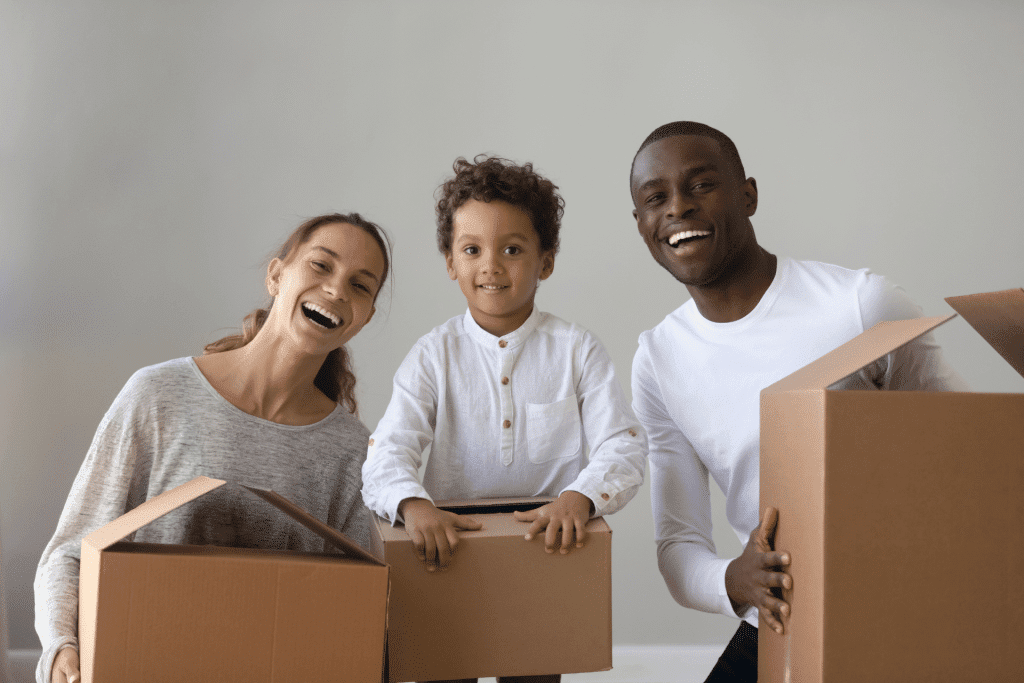 parents with their toddler carrying moving boxes