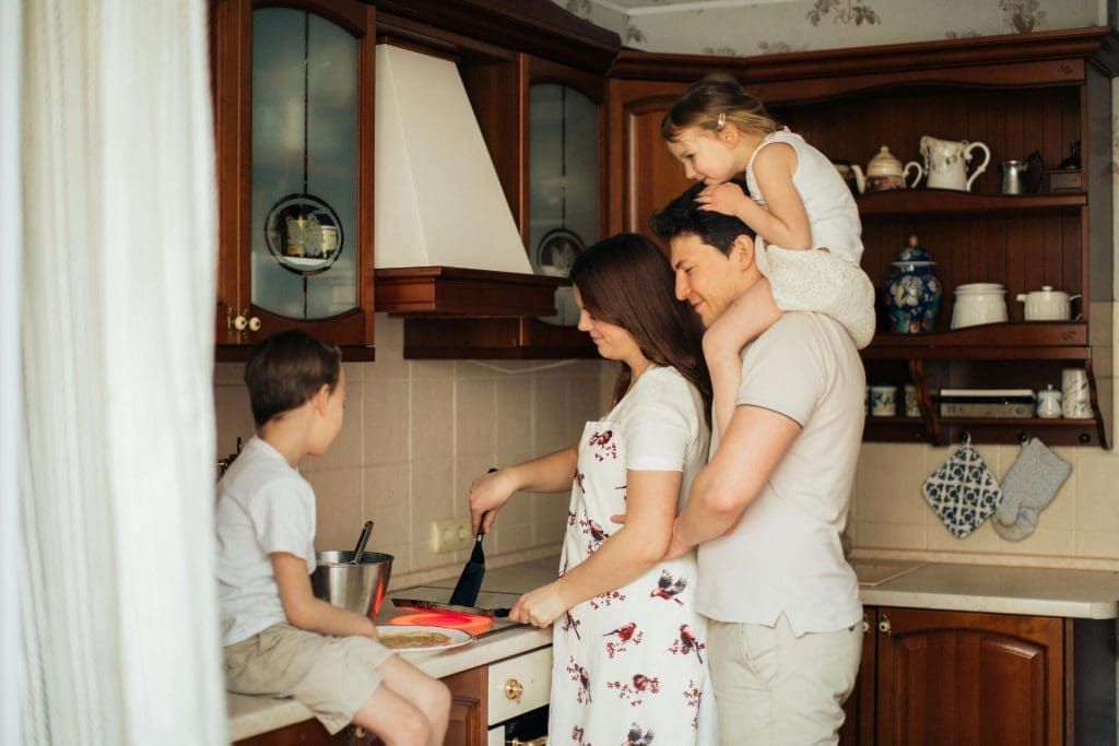 A woman cooking in front of her family to symbolize investing in single-family homes